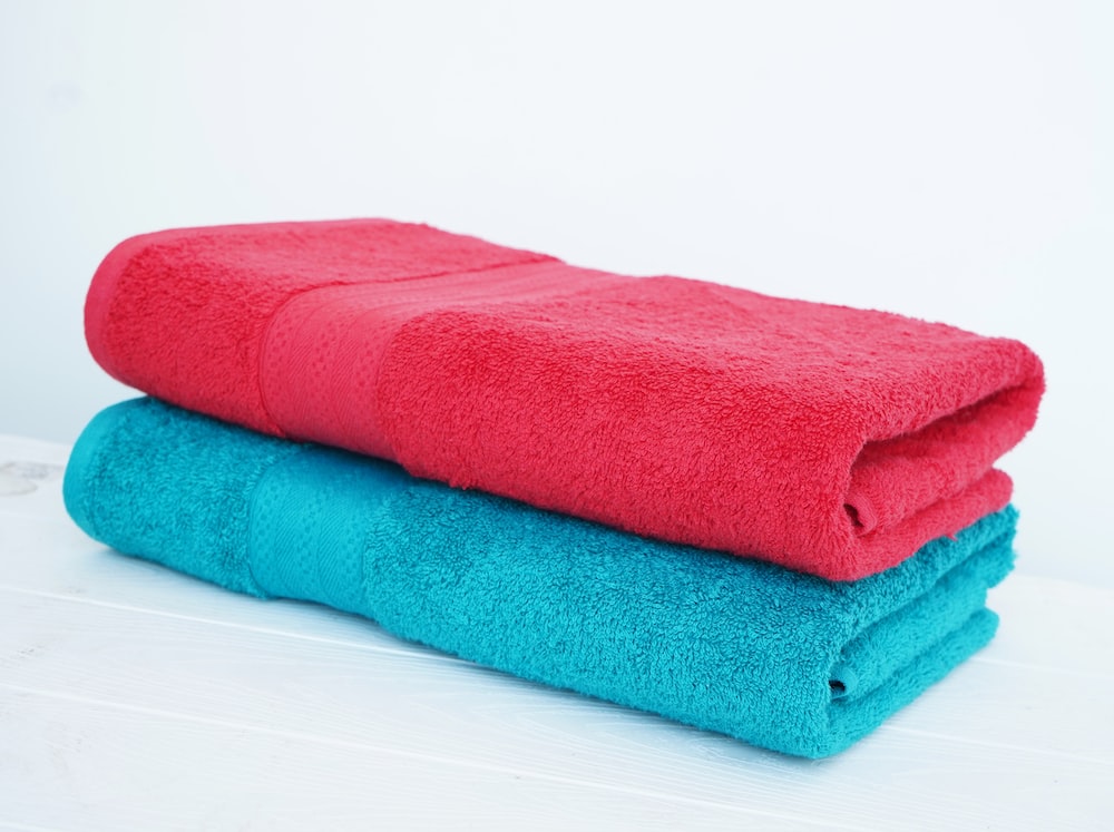 a stack of three towels sitting on top of a white table