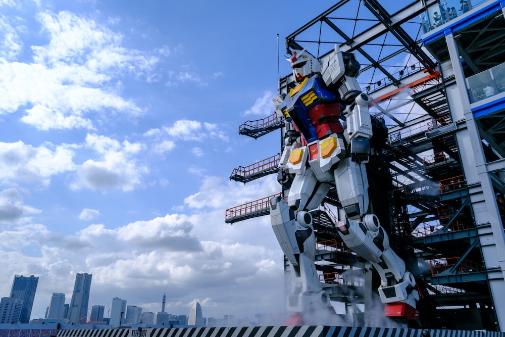 a statue of a giant robot standing in front of a tall building