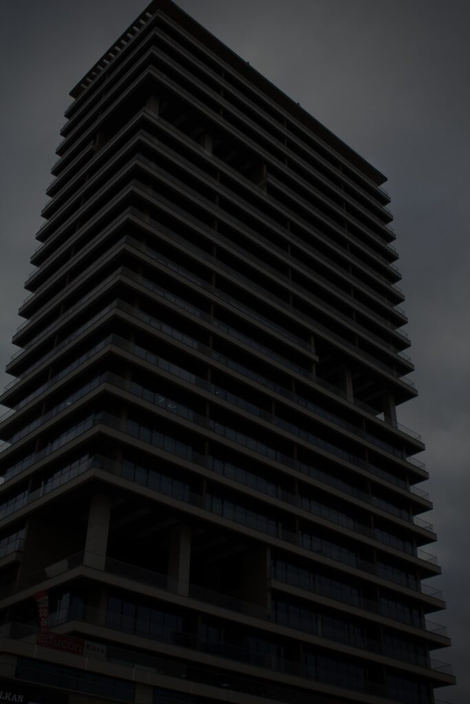 a very tall building with a very dark sky in the background