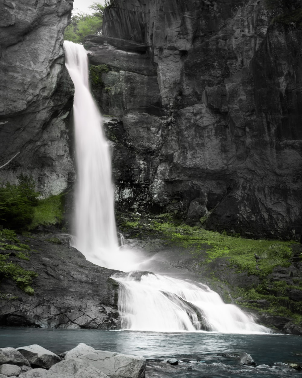 a waterfall with a large waterfall cascading down it's side