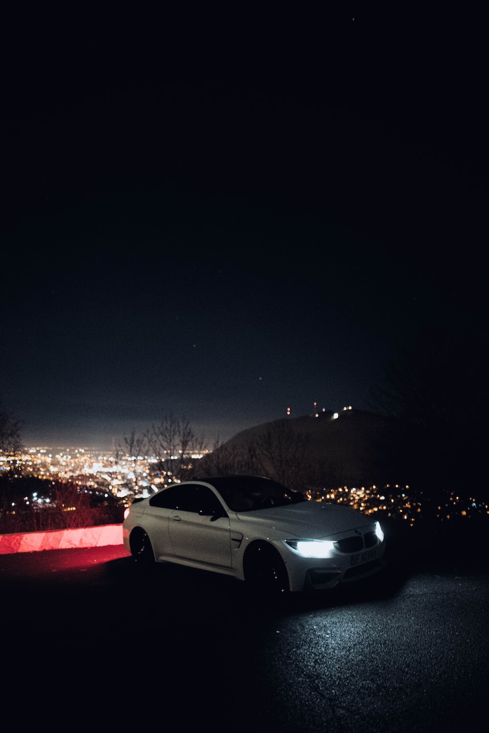 a white car parked on the side of a road at night