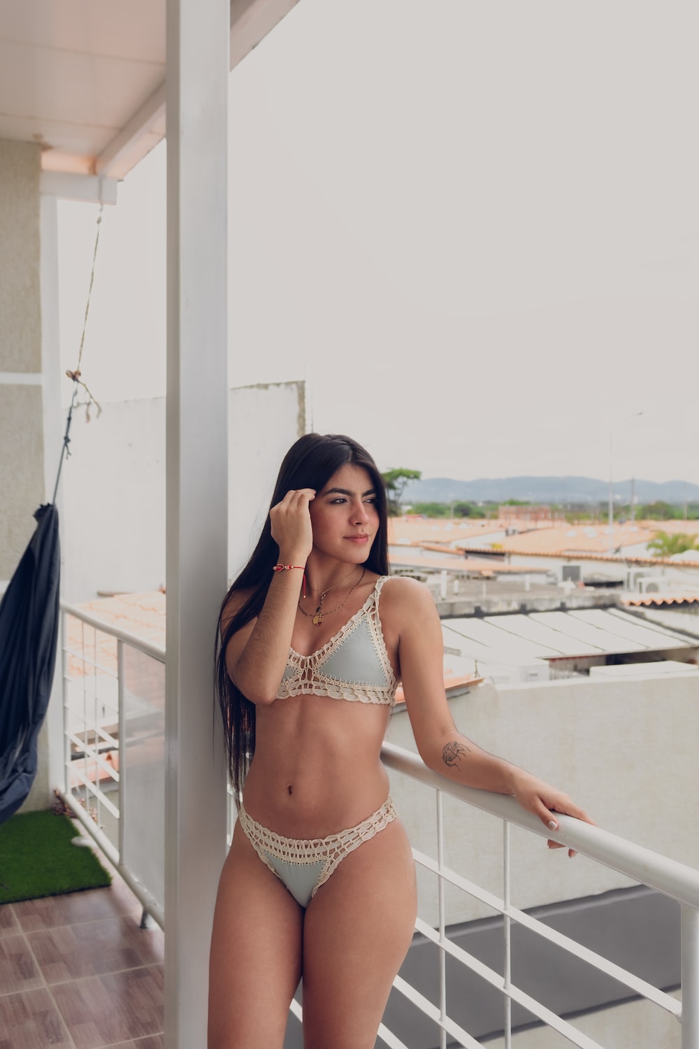 a woman in a bikini standing on a balcony