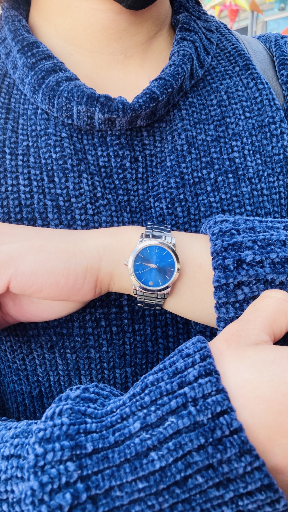 a woman wearing a blue sweater and a watch