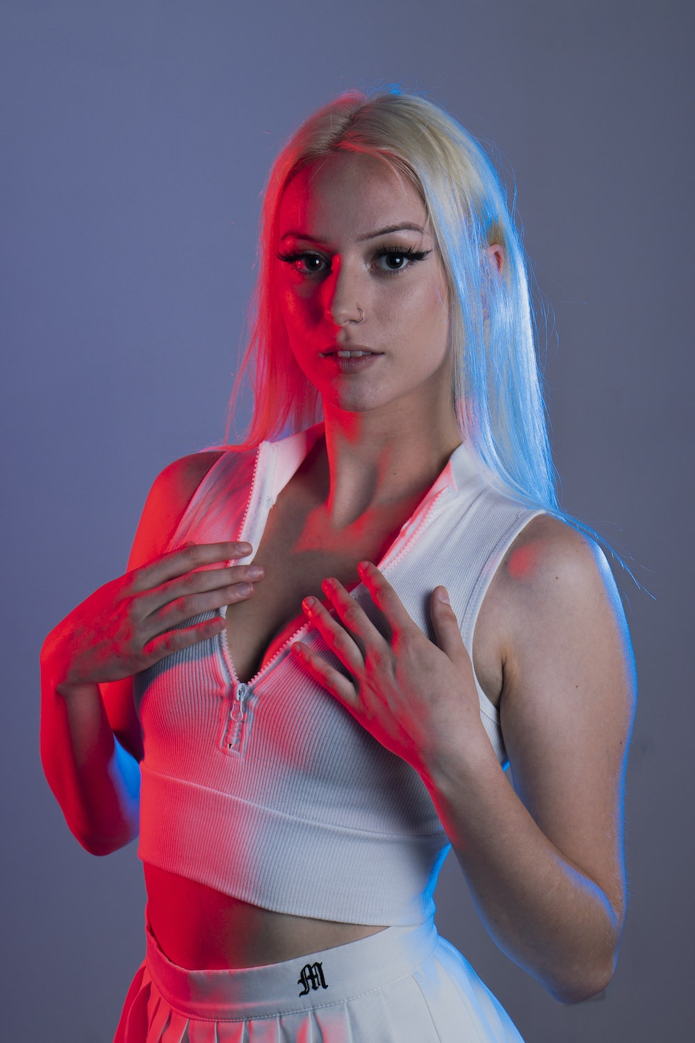 a woman with white hair and blue hair wearing a white top