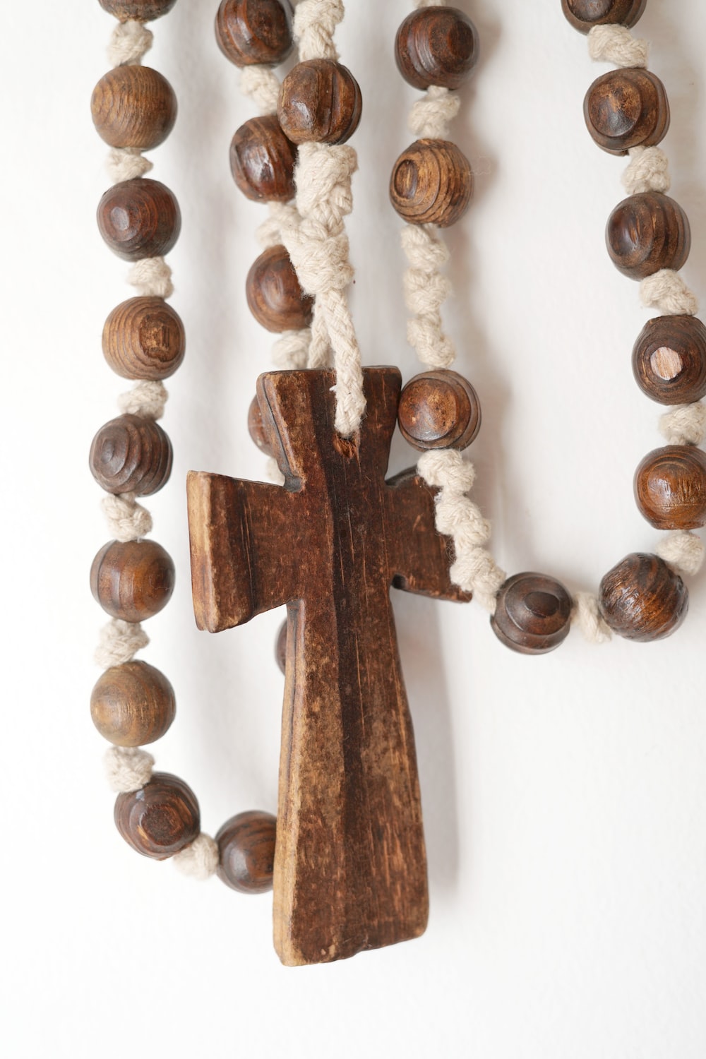 a wooden cross hanging from a white wall