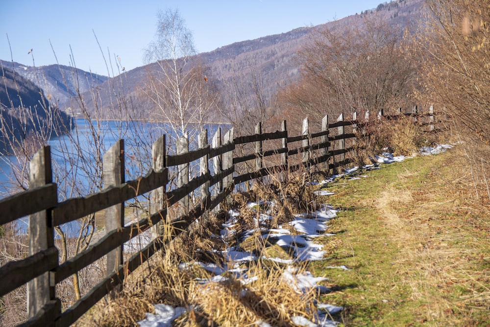 a wooden fence with snow on the ground