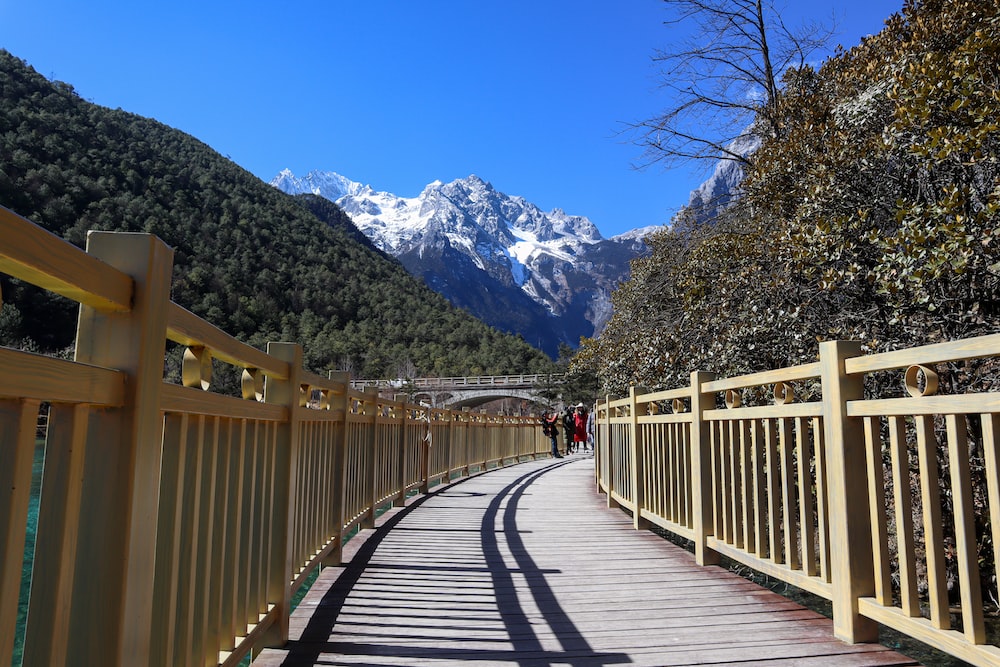 a wooden walkway with a mountain in the background
