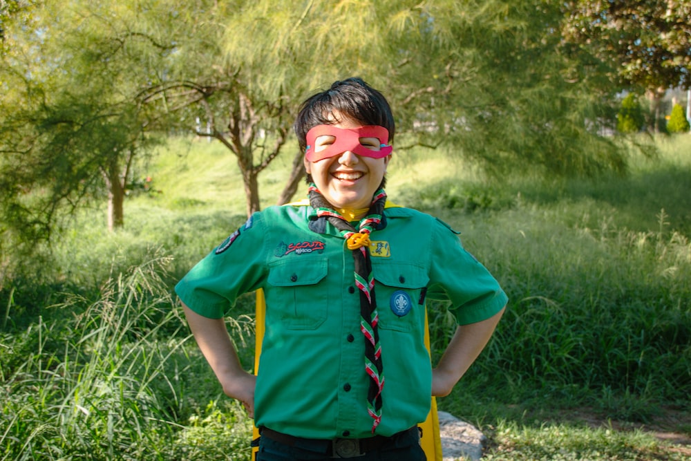 a young boy wearing a green shirt and tie