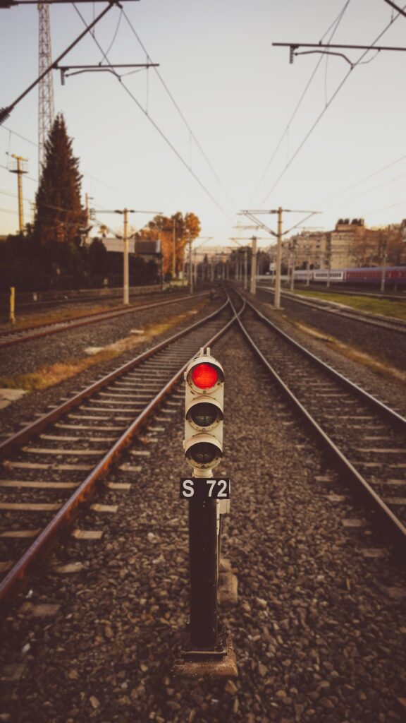 black and red traffic light on rail road