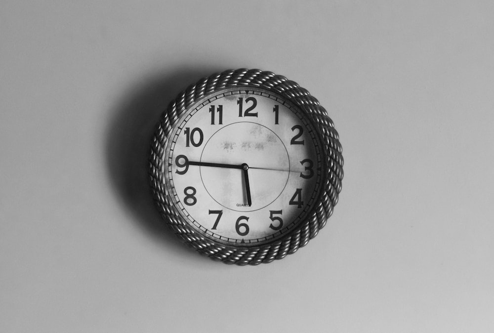 black and white analog wall clock at 10 10