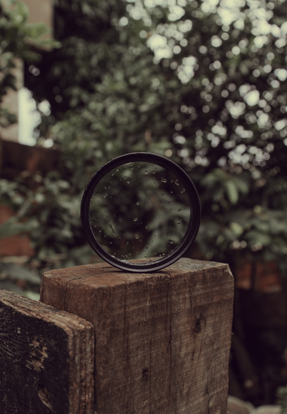 black magnifying glass on brown wooden plank