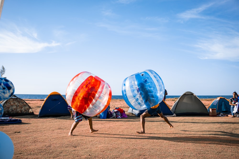 blue and orange outdoor umbrellas on brown sand during daytime