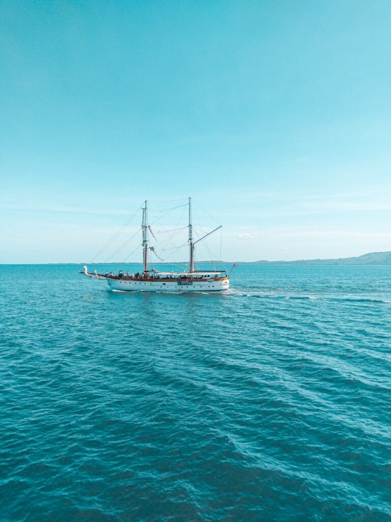 brown and white ship on sea under blue sky during daytime