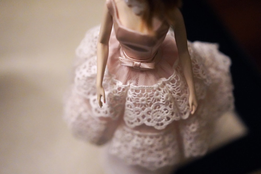 close-up of female doll wearing pink and white dress