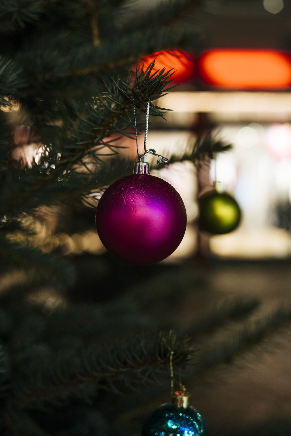 close-up selective focus shot of purple bauble hanging on Christmas tree