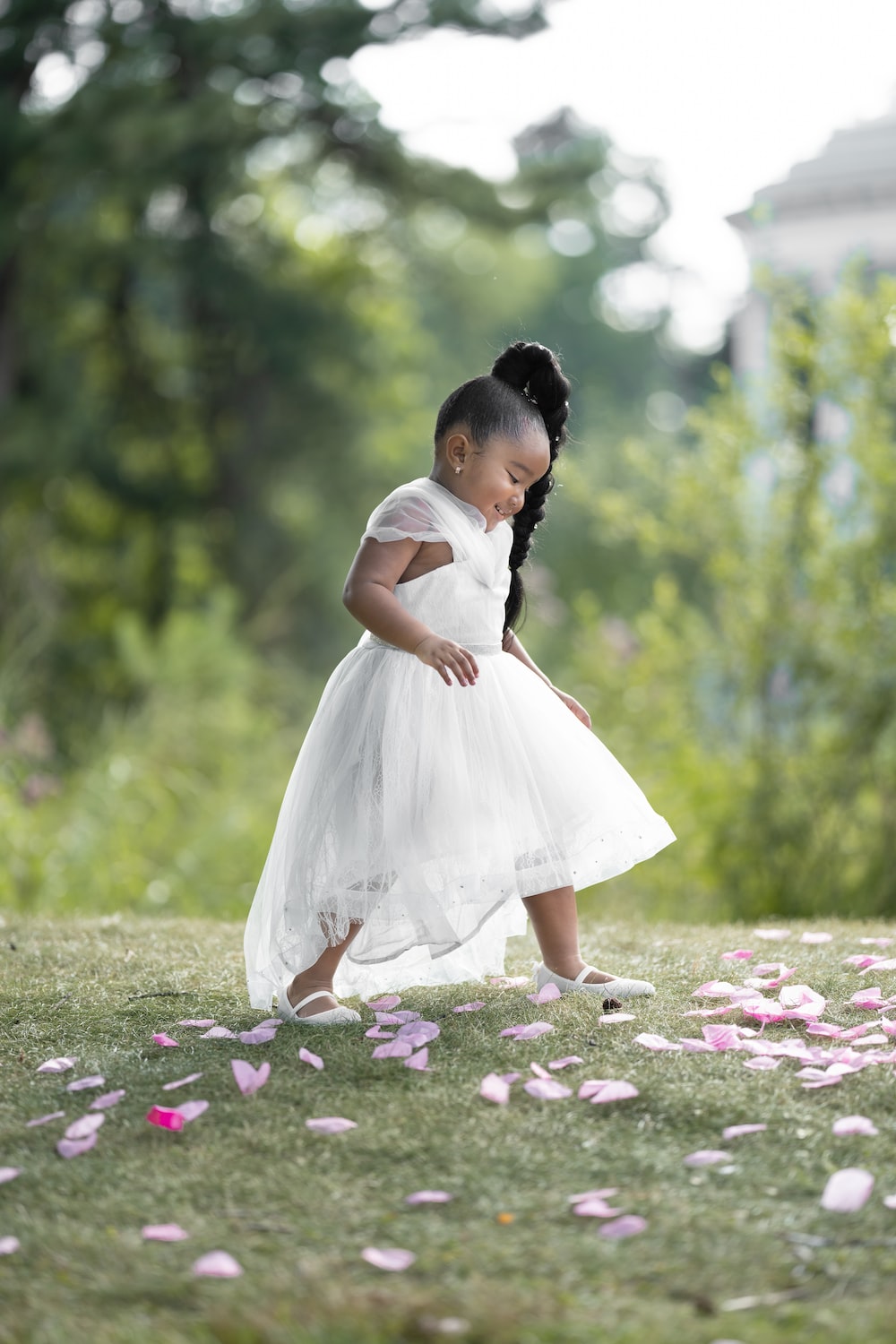 girl in white dress standing on flower field during daytime