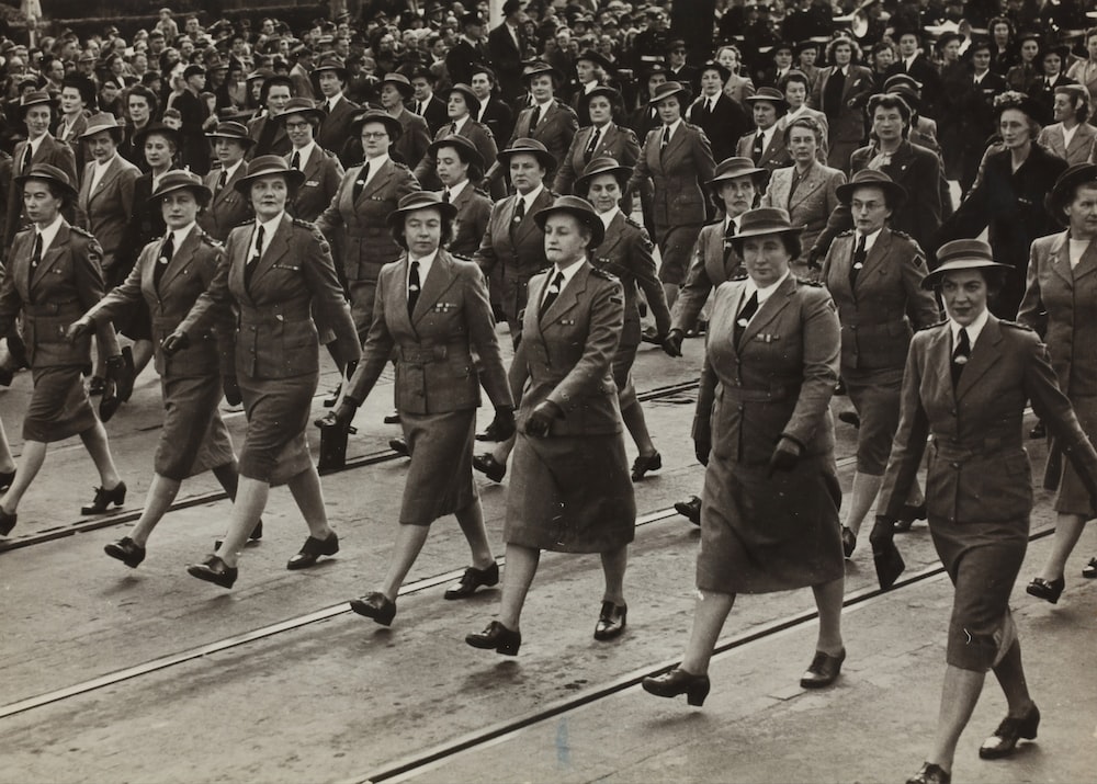 grayscale photography of group of women marching on road