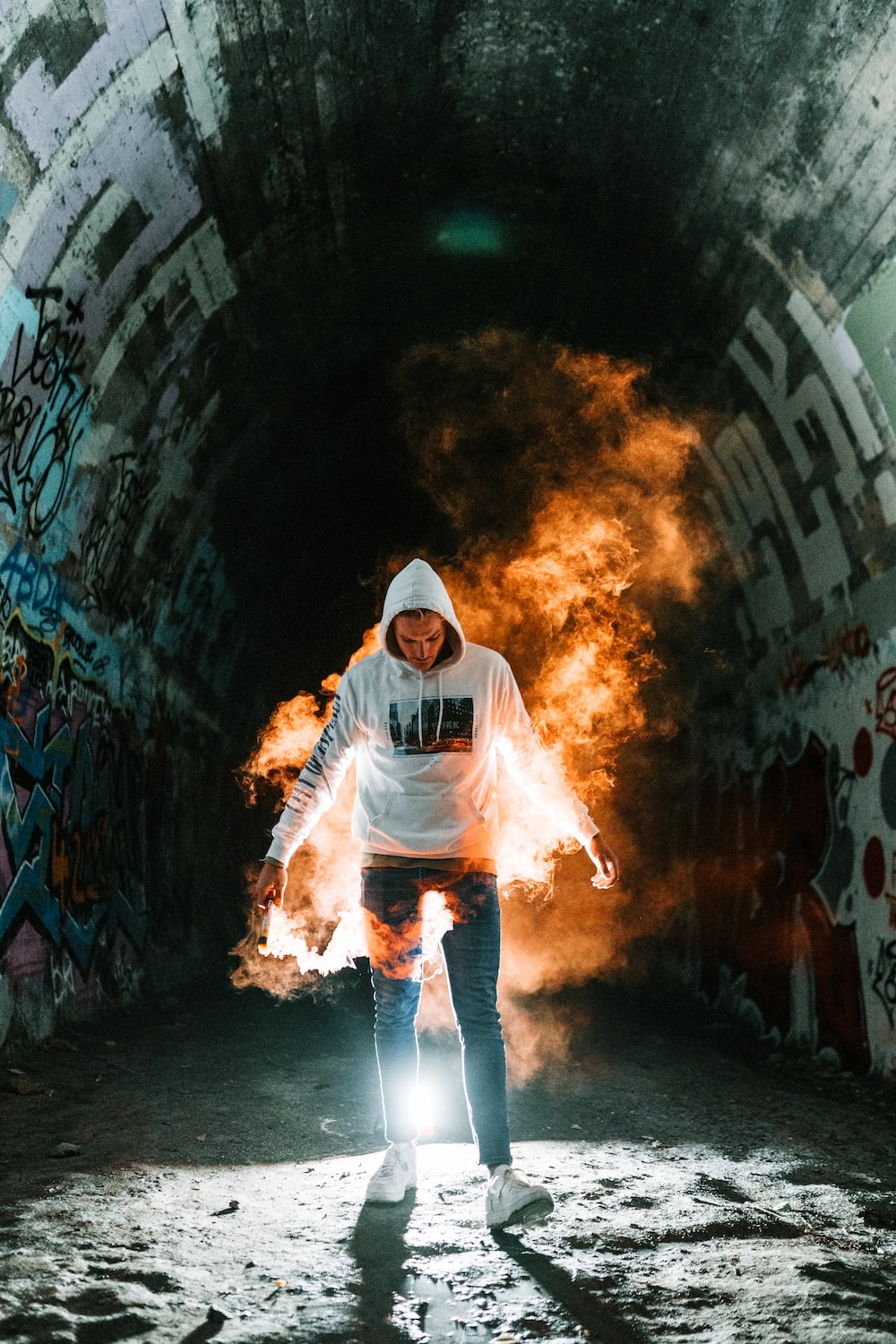 man in white hoodie and black pants standing on tunnel