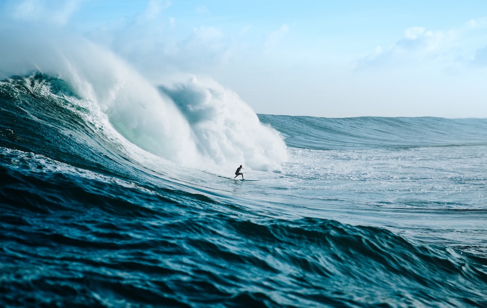 man surfing towards sea waves