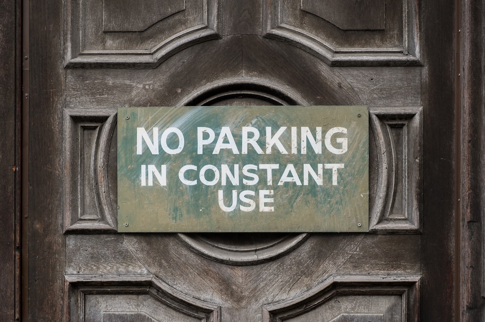 no parking in constant use signboard hung on door