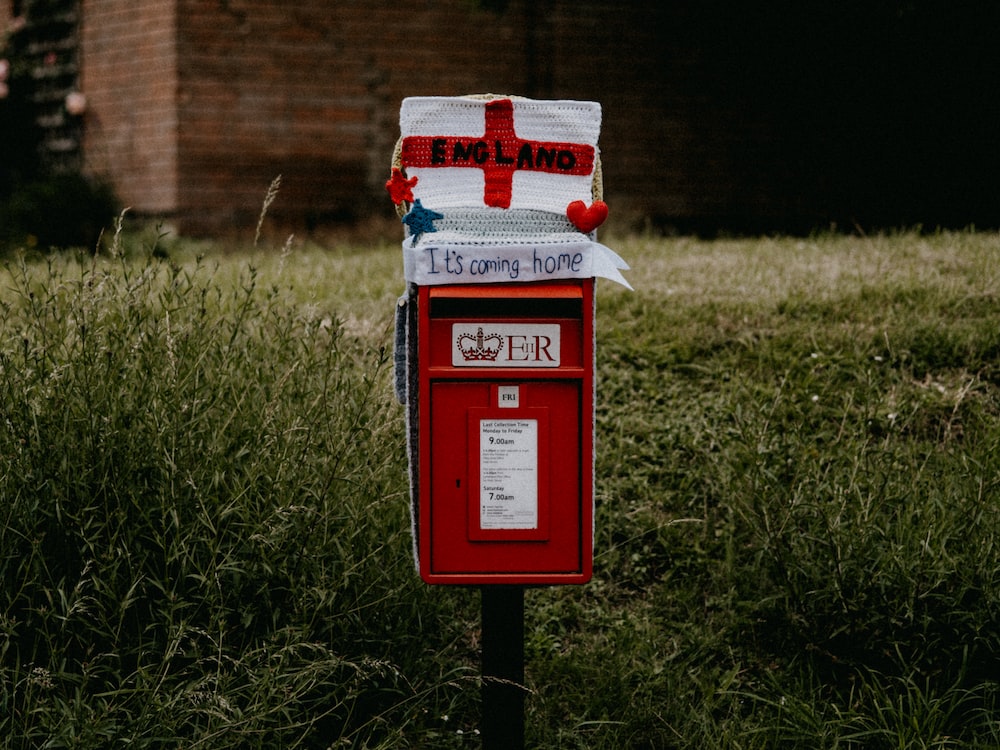 red and white mail box on green grass field