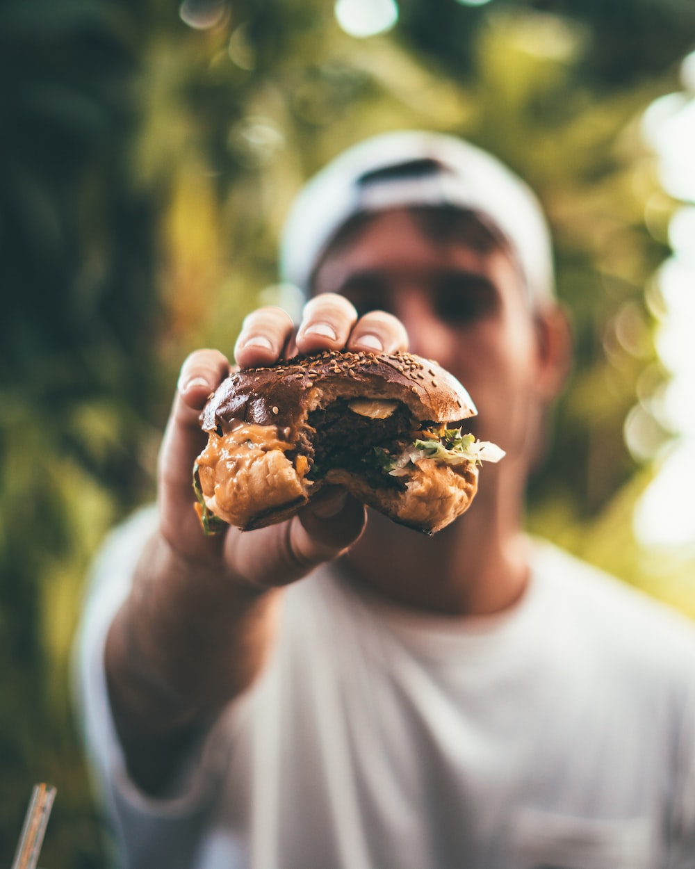 selective focus photography of man holding eaten burger