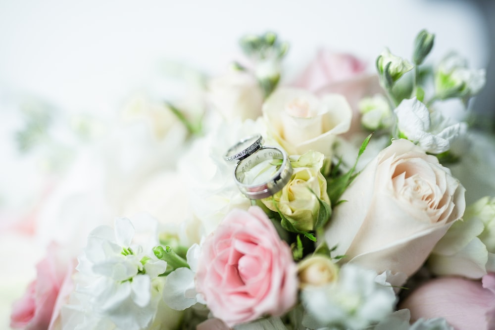silver diamond ring on white and pink roses bouquet