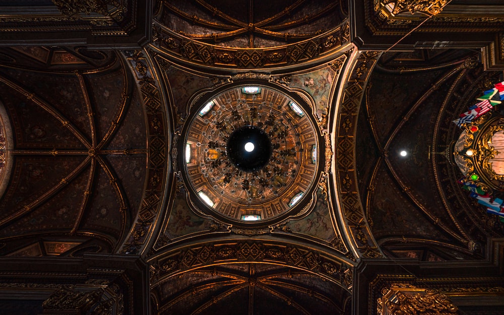 the ceiling of a church with a clock in the center