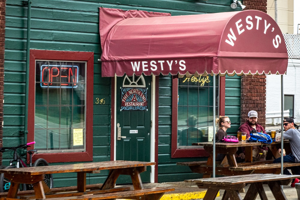 three person sits on picnic table outside the Westy's restaurant