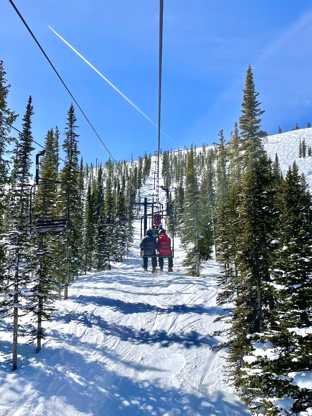 two people riding a ski lift in the snow