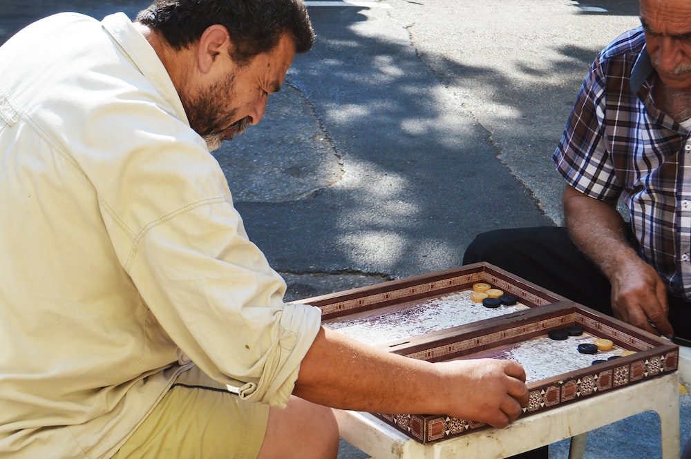 two playing board game at street