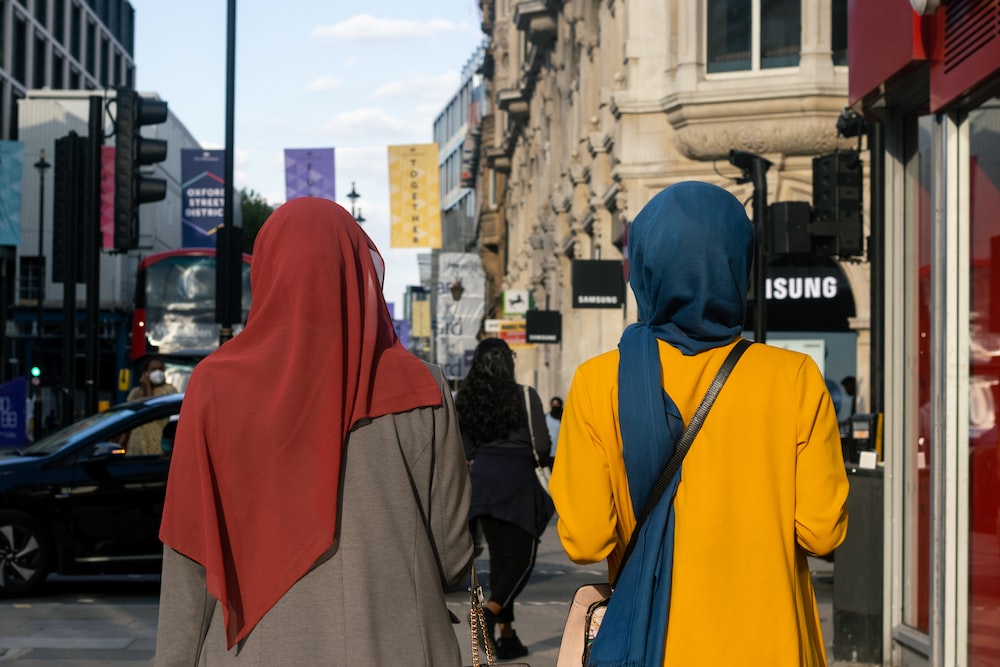 two women walking down the street in a city
