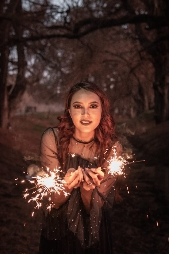 woman in brown long sleeve shirt holding sparkler