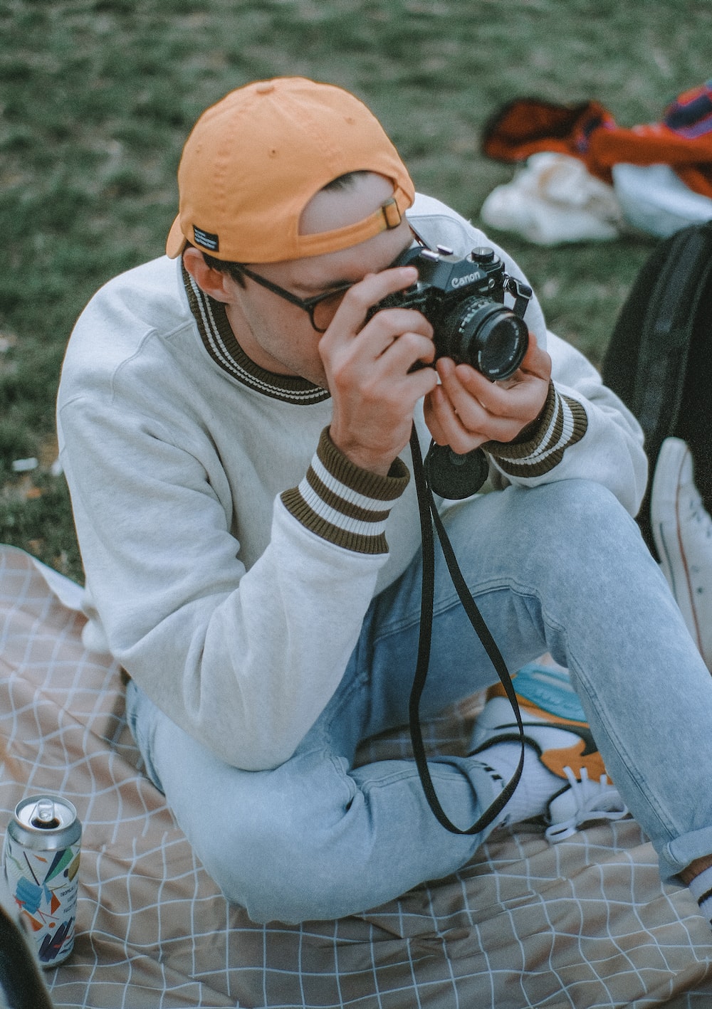 woman in white sweater and yellow knit cap holding black dslr camera